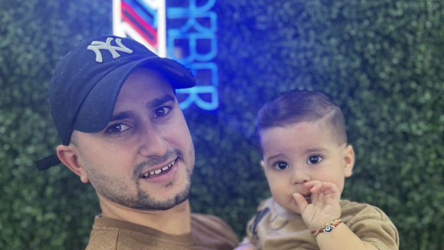 Carlos, owner of Carlis Barbershop, with his son
